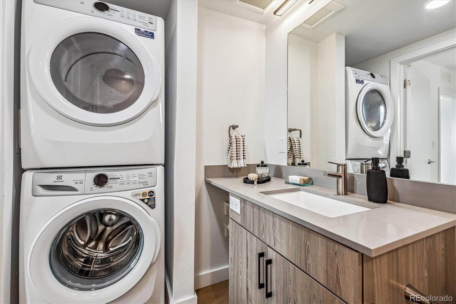 3575 Chestnut Place, Unit 605 Denver, CO 80216 - Photo 11 of 11 a bathroom with a sink a washer and dryer