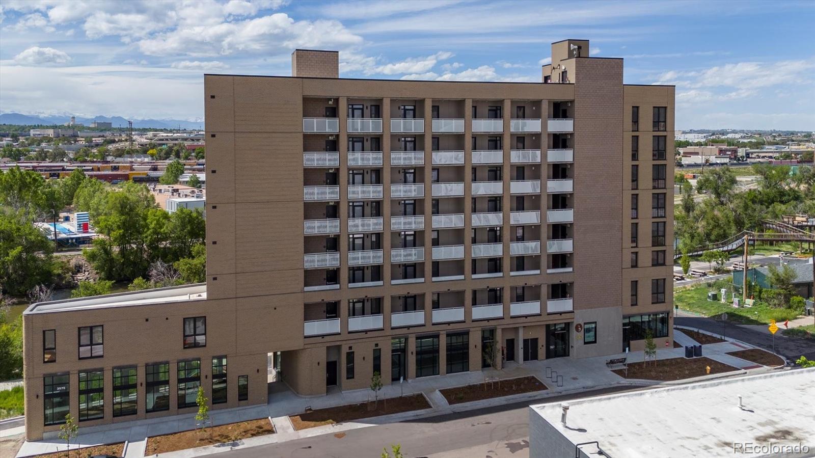 3575 Chestnut Place, Unit 605 Denver, CO 80216 - Photo 2 of 11 a front view of a building with glass windows