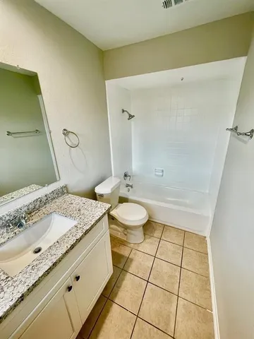 a spacious bathroom with a granite countertop sink and a mirror