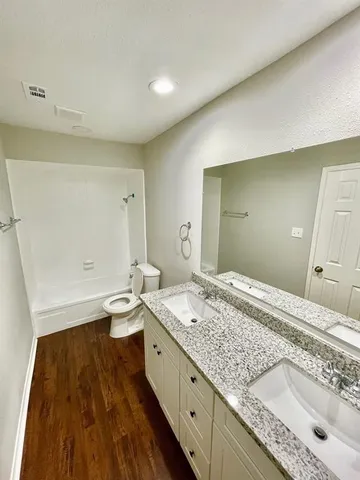 a bathroom with a double vanity sink mirror and toilet