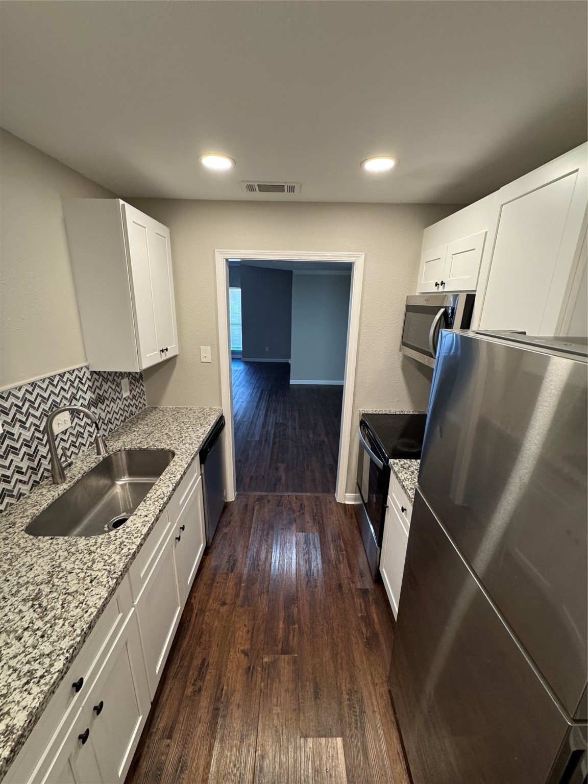 7700 Creekbend Drive, Unit 72 Houston, TX 77071 - Photo 9 of 21 a kitchen with sink cabinets and wooden floor