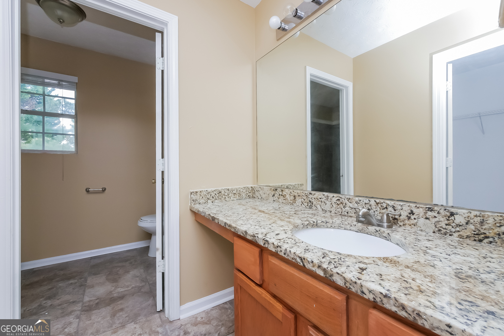 101 Bradesbury Lane Locust Grove, GA 30248 - Photo 8 of 17 a bathroom with a granite countertop sink and a mirror