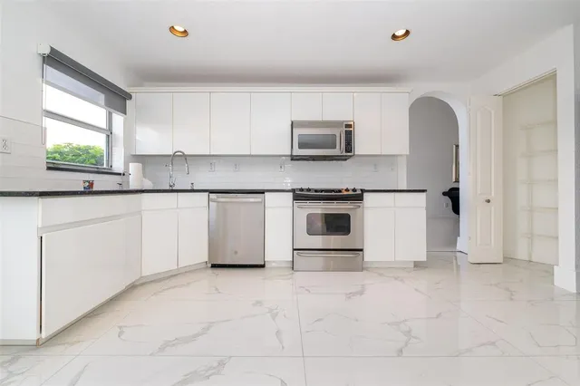 a bathroom with a white tub shower vanity and a mirror