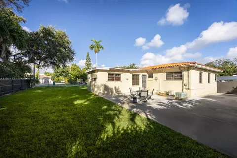 a front view of house with yard and trees in the background