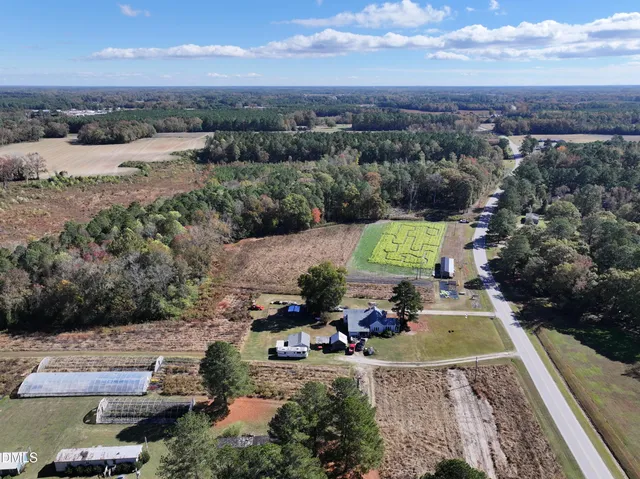 an aerial view of a house with a garden and lake view
