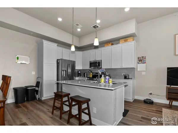 a kitchen with kitchen island a sink appliances and cabinets