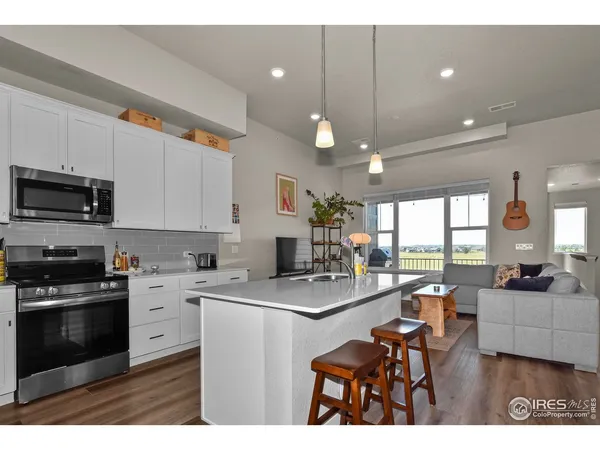 a kitchen with a sink a counter top space appliances and cabinets