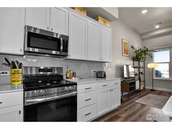 a kitchen with stainless steel appliances a stove a microwave a sink a refrigerator and cabinets