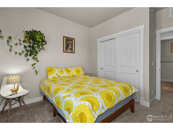 a bed sitting in a bedroom next to a lamp