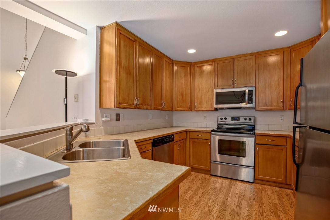 19131 110th Place Southeast Renton, WA 98055 - Photo 11 of 25 a kitchen with stainless steel appliances granite countertop a sink a stove and microwave