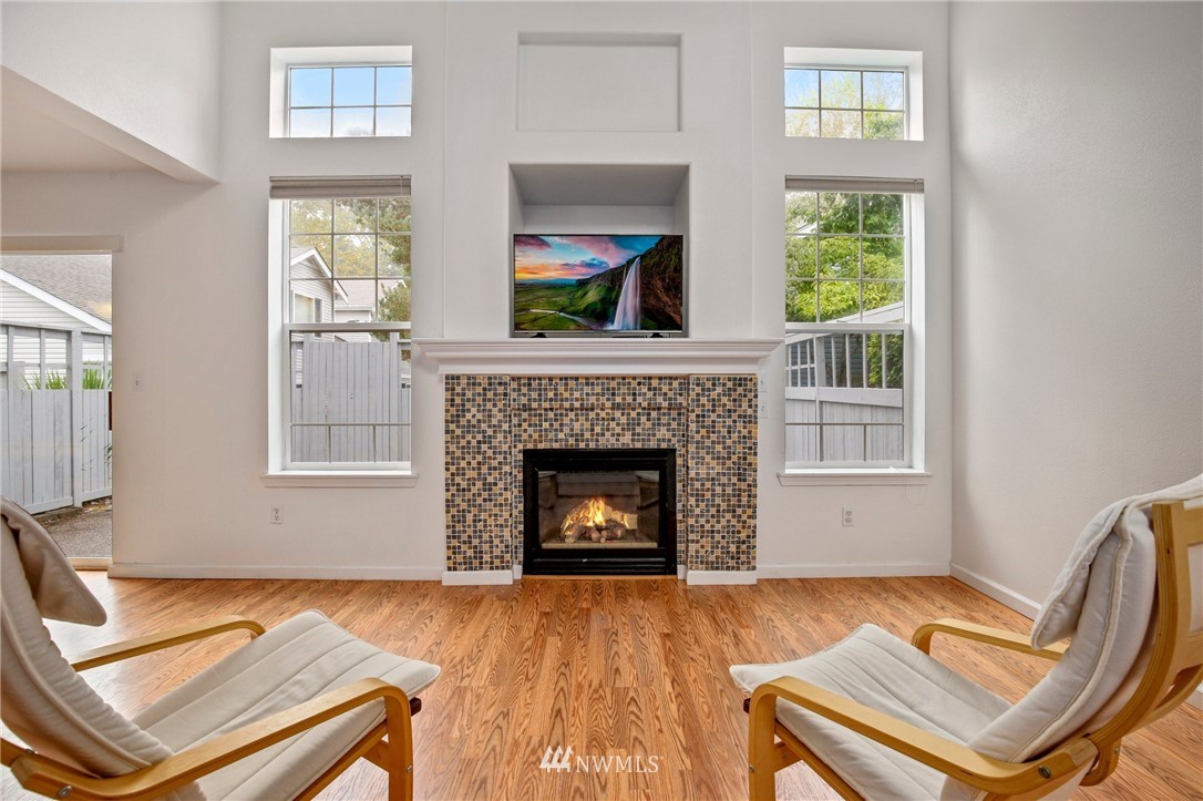 19131 110th Place Southeast Renton, WA 98055 - Photo 6 of 25 a living room with a fireplace windows and a fireplace