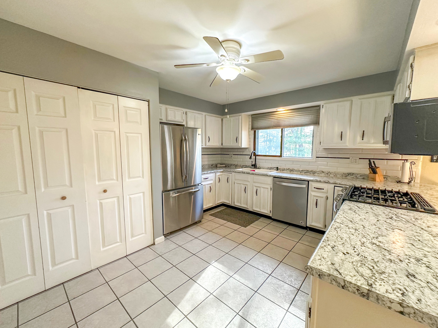 6315 North Post Oak Road Peoria, IL 61615 - Photo 6 of 31 a kitchen with a sink a stove cabinets and white stainless steel appliances