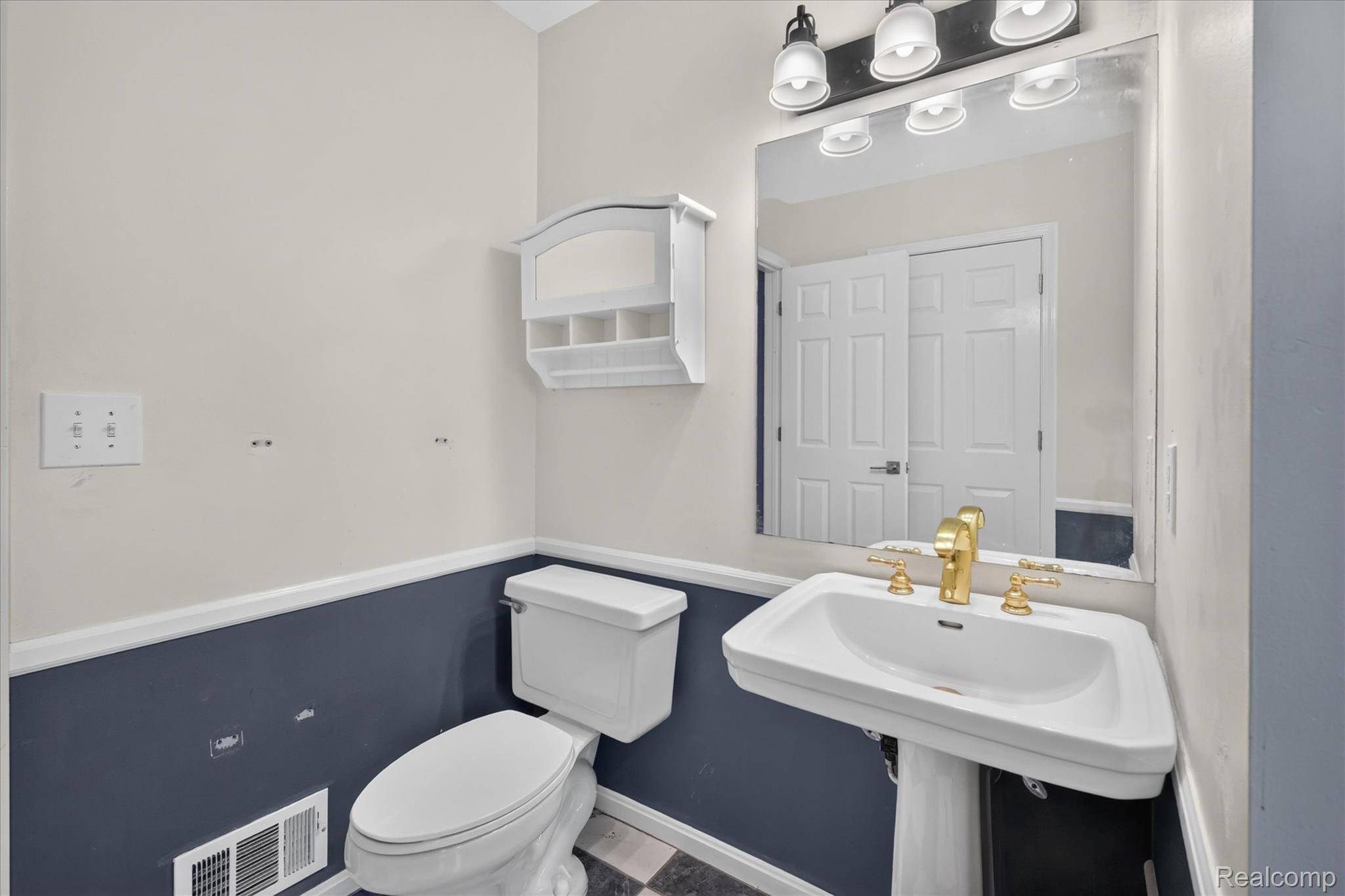 8114 Chilson Road Pinckney, MI 48169 - Photo 26 of 32 Pedestal sink with gold-finish faucet hardware and a wall-mounted mirror