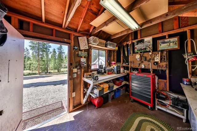 a view of a house with a small yard and a large tree