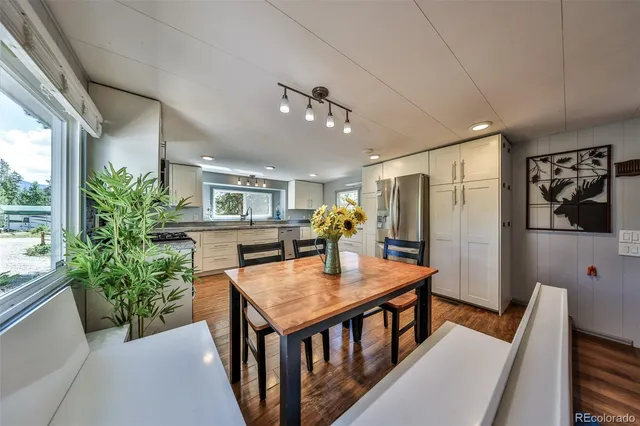 a kitchen with stainless steel appliances granite countertop a stove top oven a sink and white cabinets