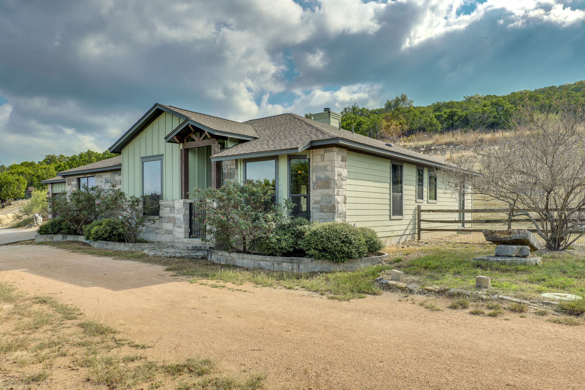 10837 Deer Canyon Road Jonestown, TX 78645 - Photo 3 of 19 a front view of a house with a garden and plants