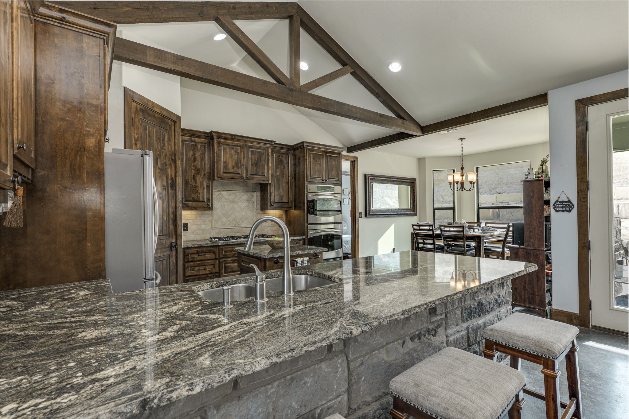10837 Deer Canyon Road Jonestown, TX 78645 - Photo 6 of 19 a dining hall with stainless steel appliances granite countertop a stove and a sink