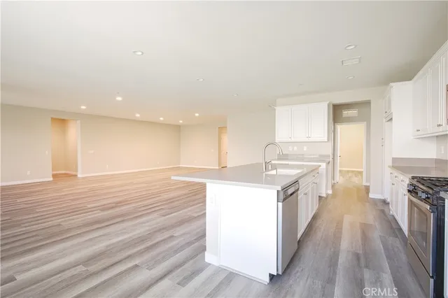 a large kitchen with kitchen island white cabinets and wooden floor