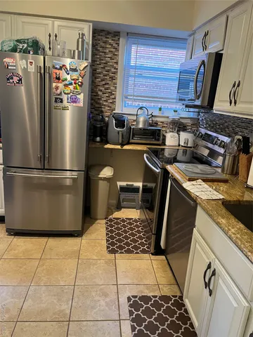 a kitchen with a sink a refrigerator and cabinets