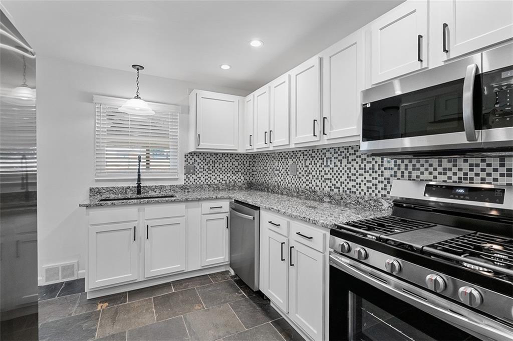 1858 Brodhead Road Aliquippa, PA 15001 - Photo 12 of 27 a kitchen with granite countertop a stove sink and microwave