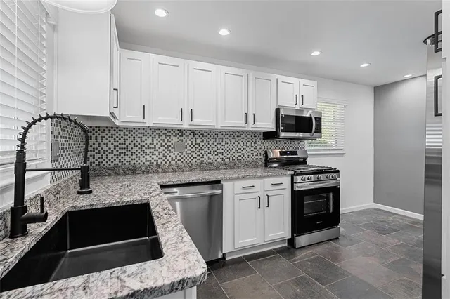 a kitchen with a sink and stove top oven