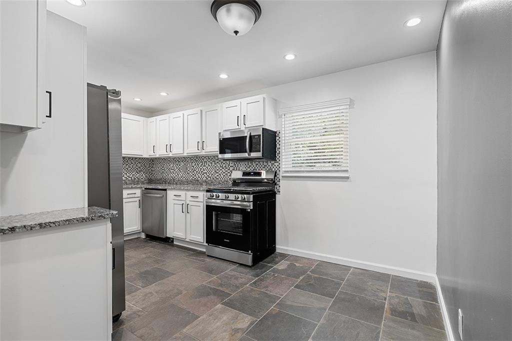 1858 Brodhead Road Aliquippa, PA 15001 - Photo 10 of 27 a kitchen with granite countertop a stove a sink and a microwave
