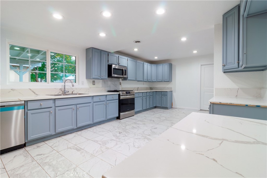 9668 East Ave R 14 Littlerock, CA 93543 - Photo 13 of 34 a large kitchen with kitchen island a sink a stove a center island a counter top space and cabinets