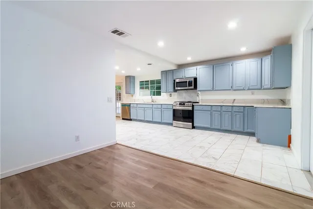 a large kitchen with cabinets and wooden floor