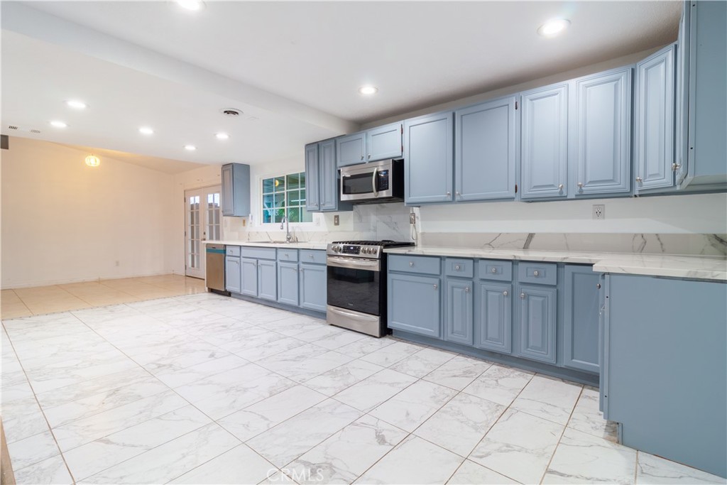 9668 East Ave R 14 Littlerock, CA 93543 - Photo 17 of 34 a kitchen with stainless steel appliances granite countertop a stove top oven a sink and dishwasher