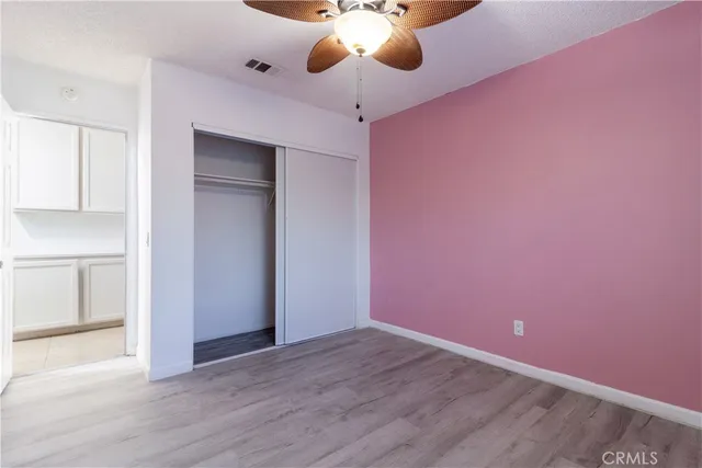 a view of an empty room with a chandelier fan