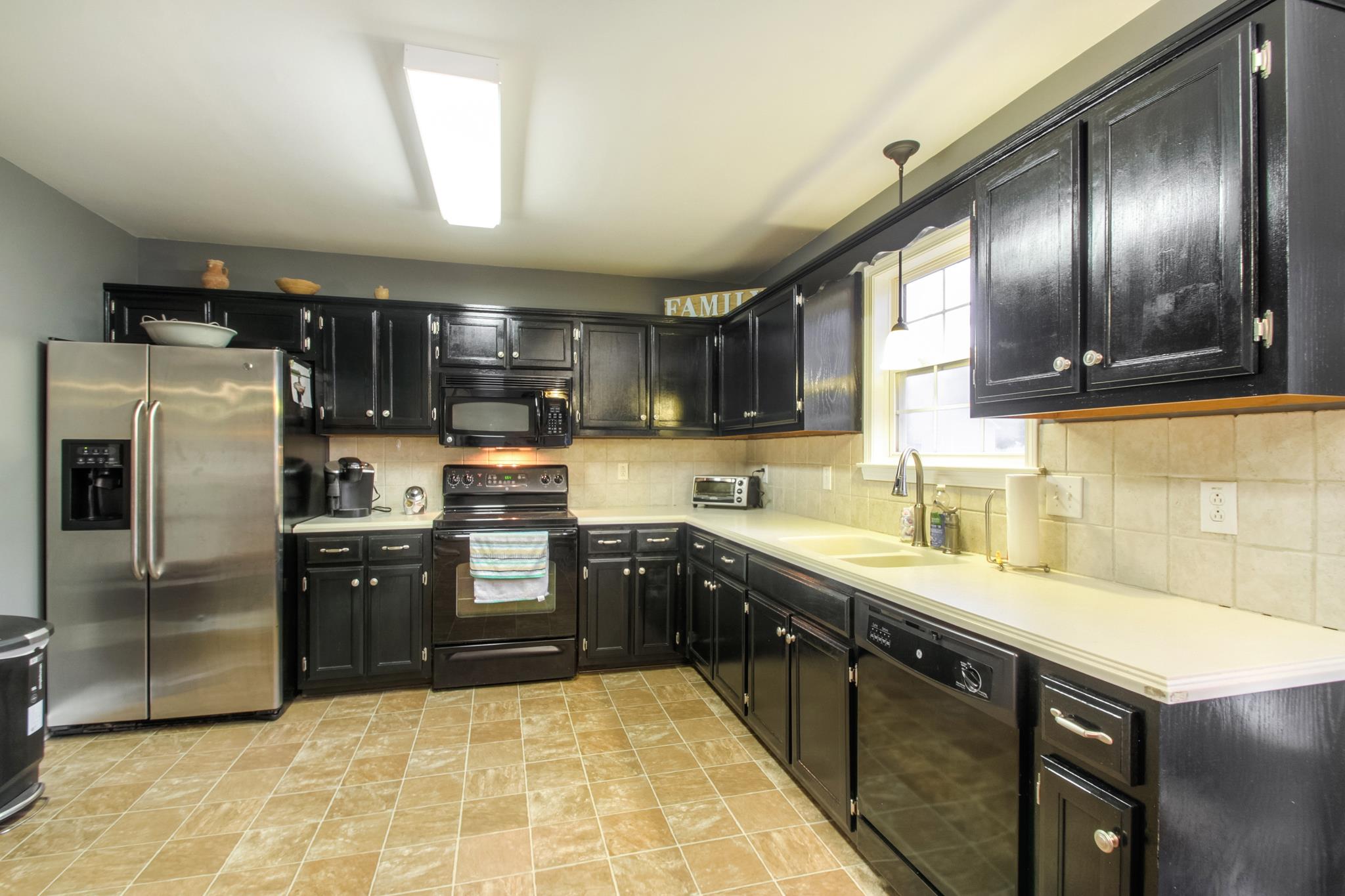 2832 Rippavilla Way Spring Hill, TN 37174 - Photo 6 of 14 a large kitchen with stainless steel appliances granite countertop a sink a stove and a refrigerator