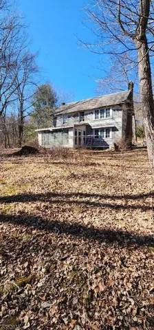 a front view of a house with a large tree