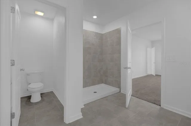 a bathroom with a granite countertop sink a toilet and shower