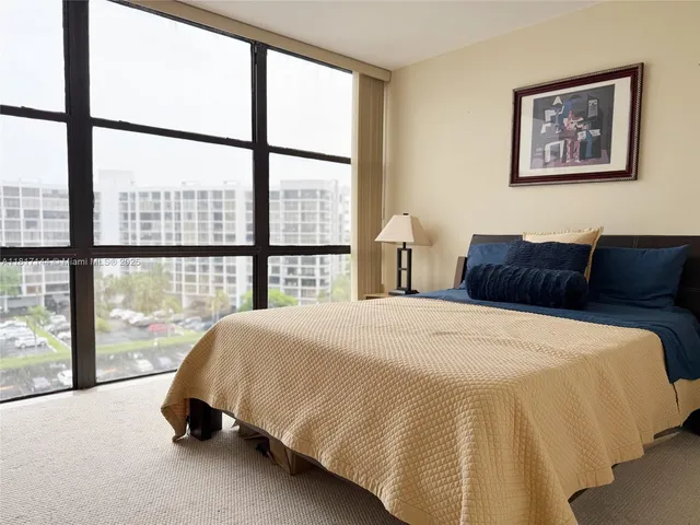 a bedroom with bed and a large window