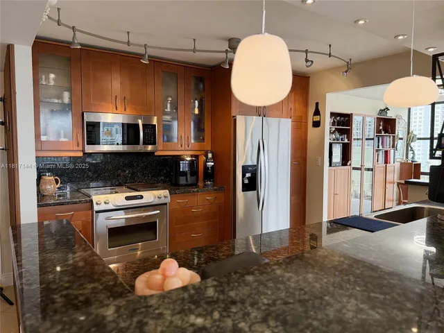 a large kitchen with stainless steel appliances lots of counter space and a sink