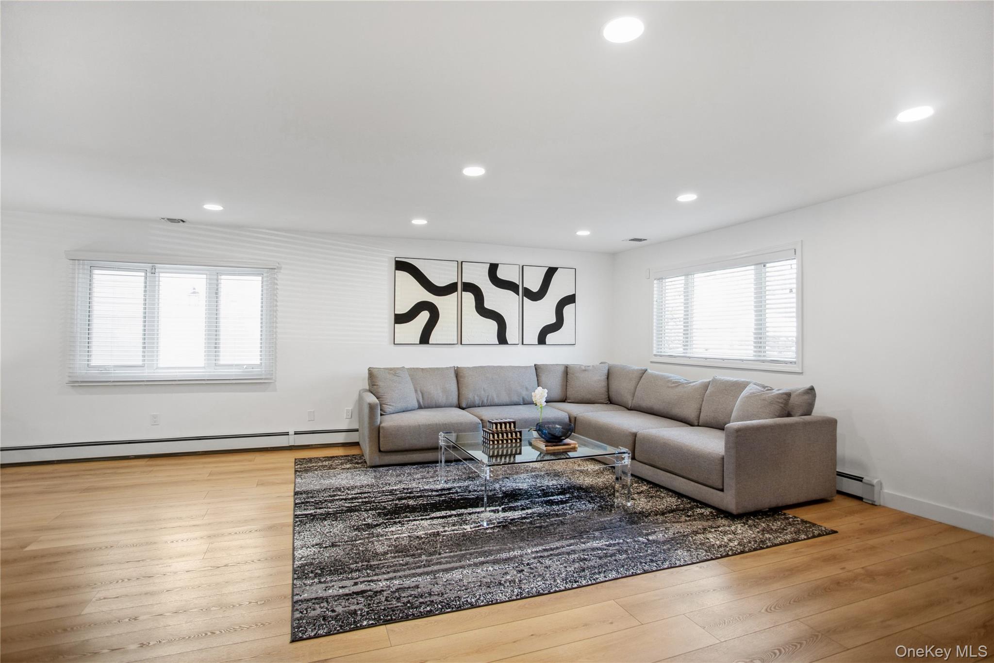 110 Hampton Way Merrick, NY 11566 - Photo 13 of 24 Living room with recessed lighting, light wood finished floors, and a baseboard heating unit