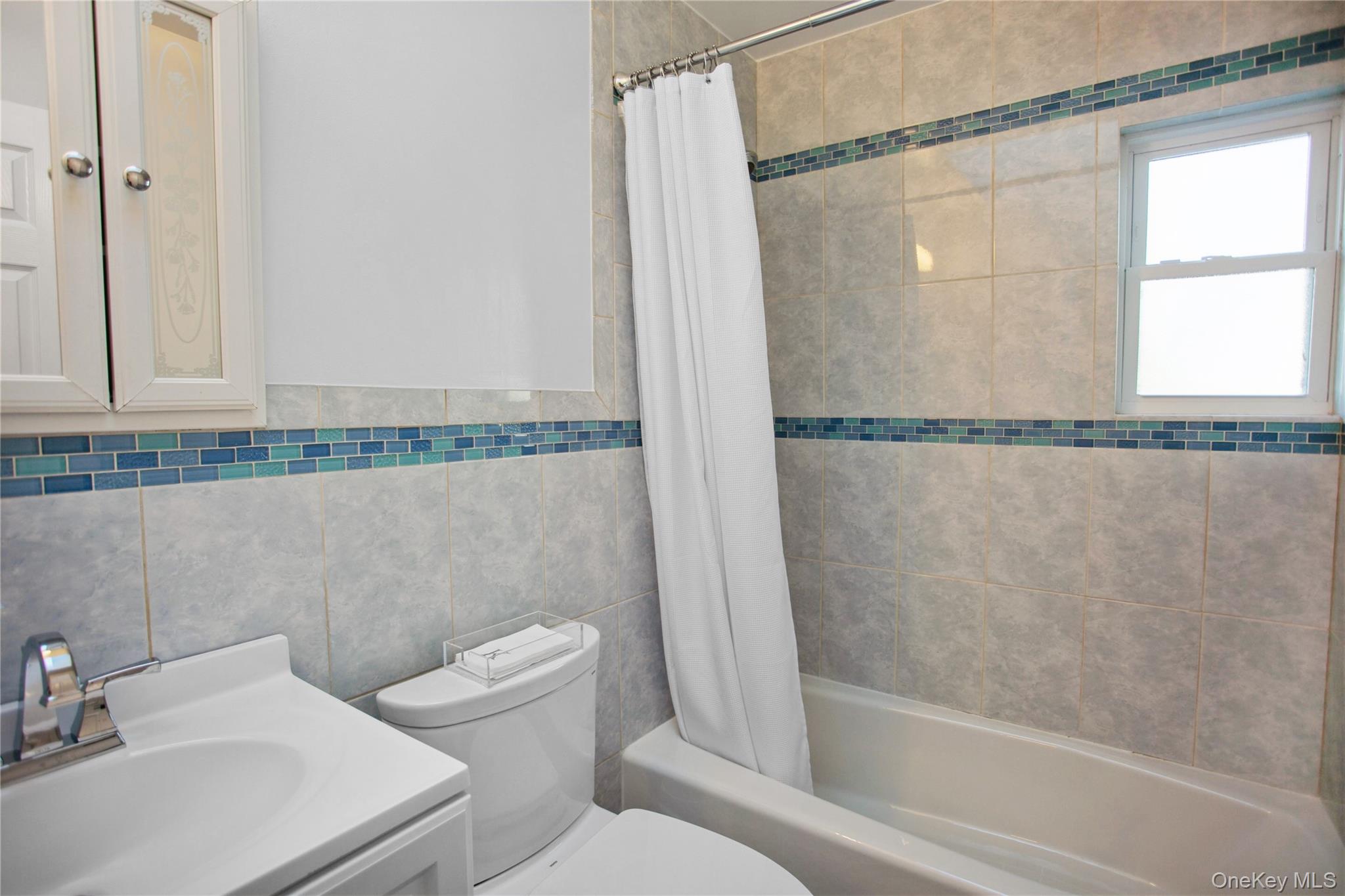 110 Hampton Way Merrick, NY 11566 - Photo 19 of 24 Full bath featuring shower / bath combination with curtain, vanity, and tile walls