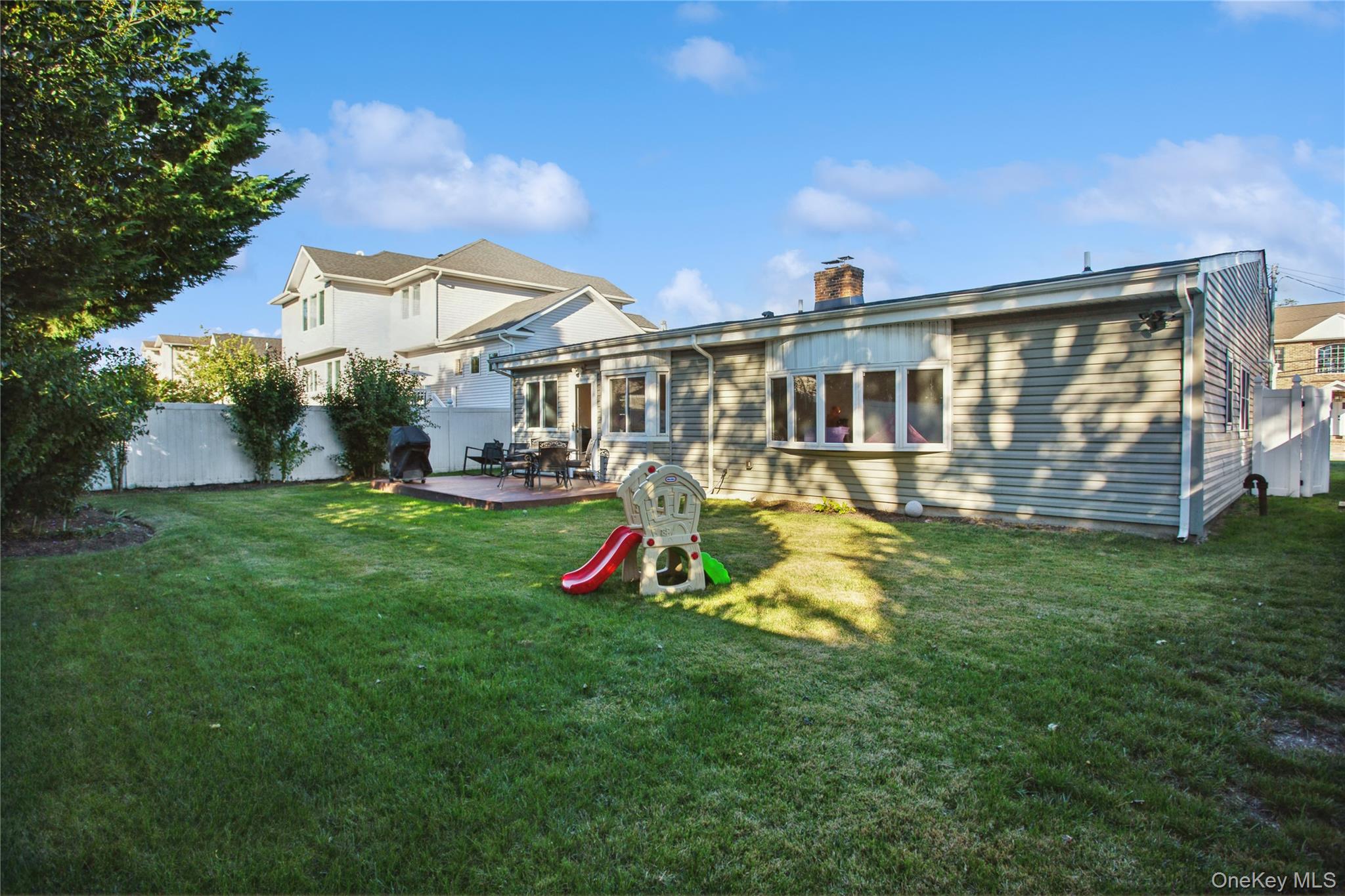 110 Hampton Way Merrick, NY 11566 - Photo 20 of 24 Rear view of house with a wooden deck and a chimney
