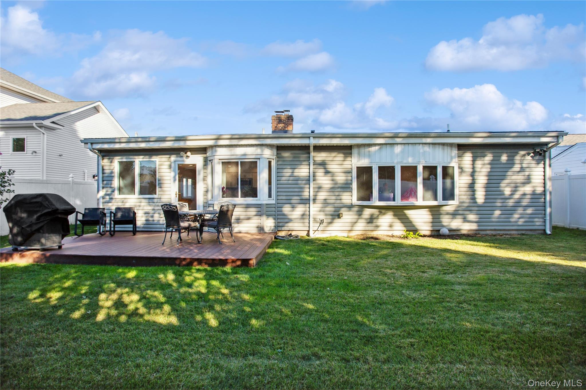 110 Hampton Way Merrick, NY 11566 - Photo 21 of 24 Back of property featuring a wooden deck and a chimney