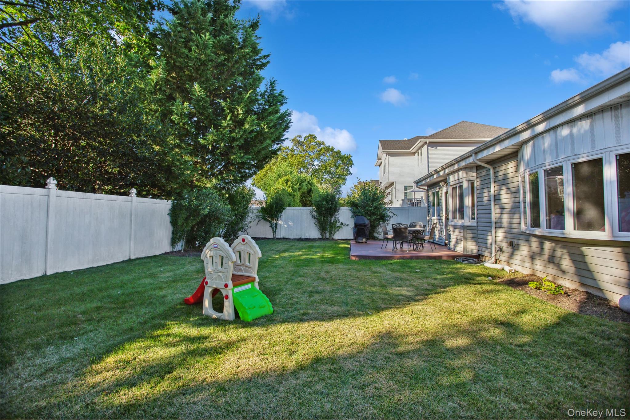 110 Hampton Way Merrick, NY 11566 - Photo 23 of 24 Fenced backyard with a wooden deck