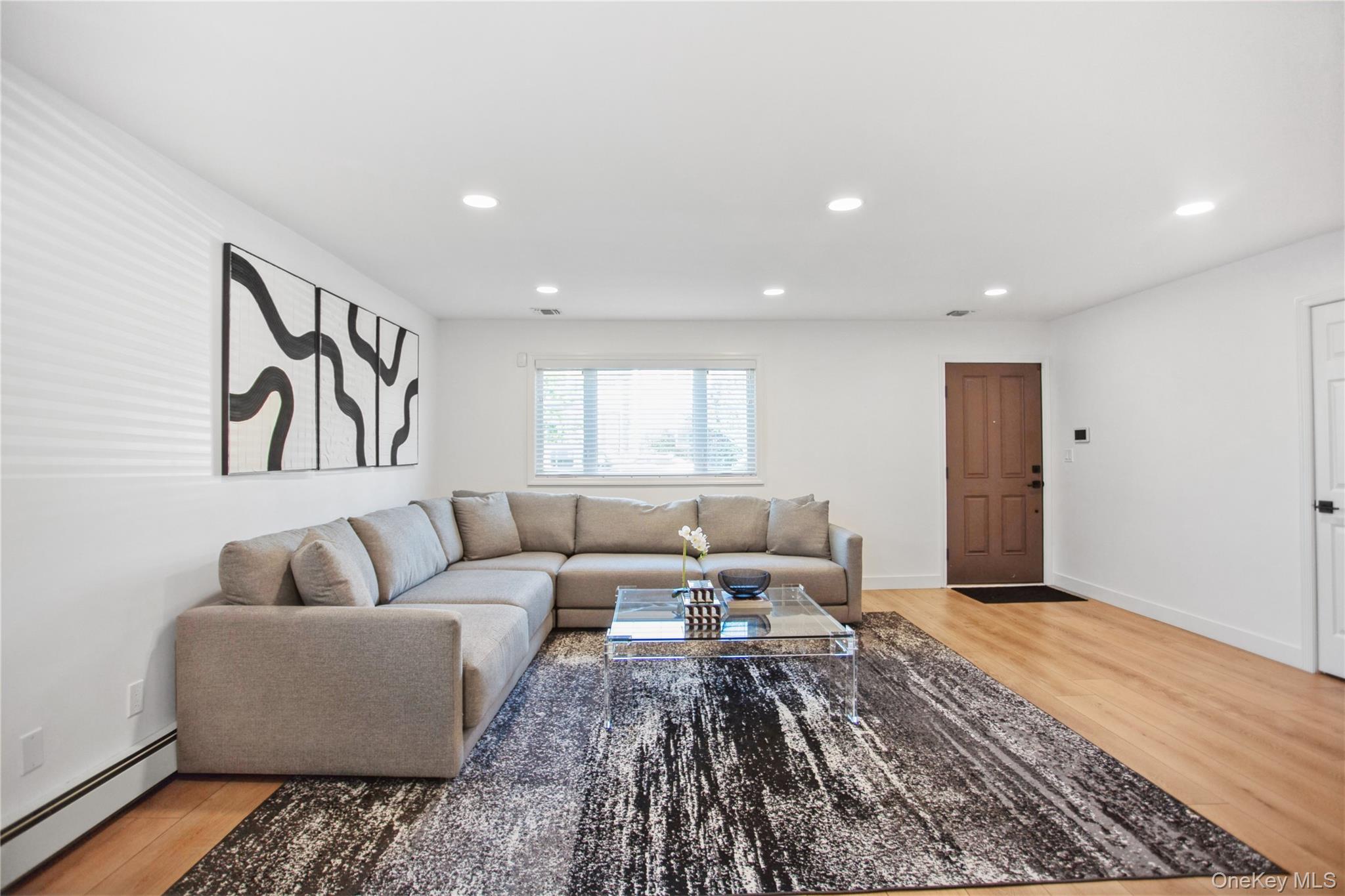 110 Hampton Way Merrick, NY 11566 - Photo 3 of 24 Living room featuring a baseboard radiator, recessed lighting, and light wood-style flooring