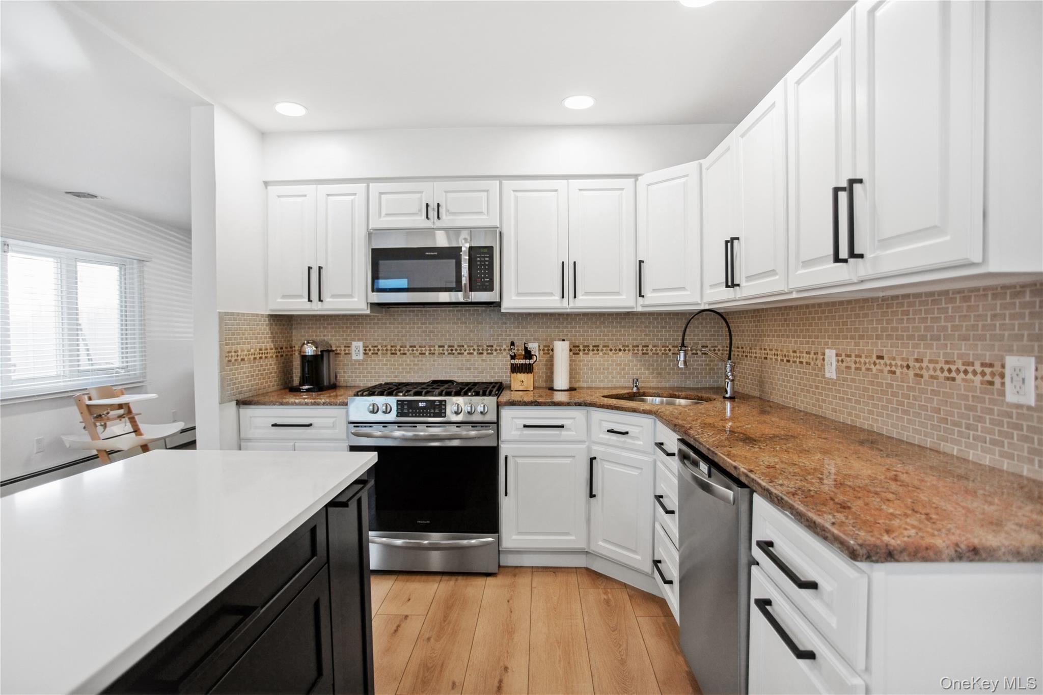 110 Hampton Way Merrick, NY 11566 - Photo 8 of 24 Kitchen with white cabinets, stainless steel appliances, light wood finished floors, dark cabinetry, and recessed lighting