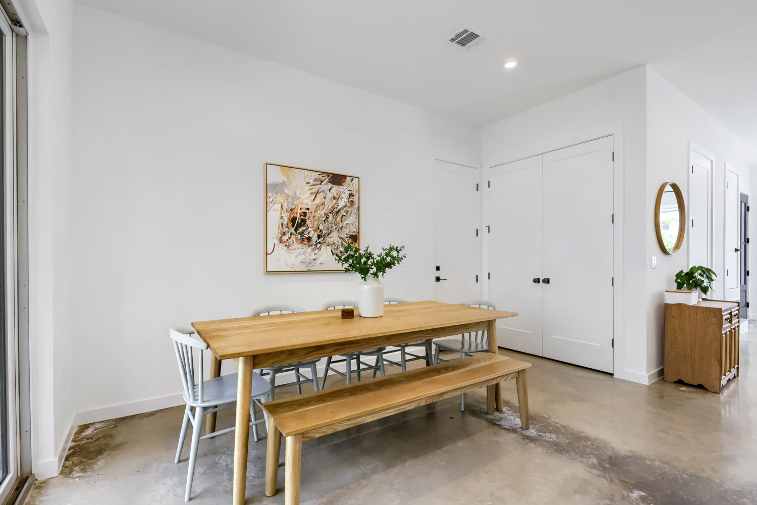 4804 Ribbecke Avenue, Unit A Austin, TX 78721 - Photo 7 of 32 This spacious dining area features a light wood table, concrete flooring, and a large window providing natural light