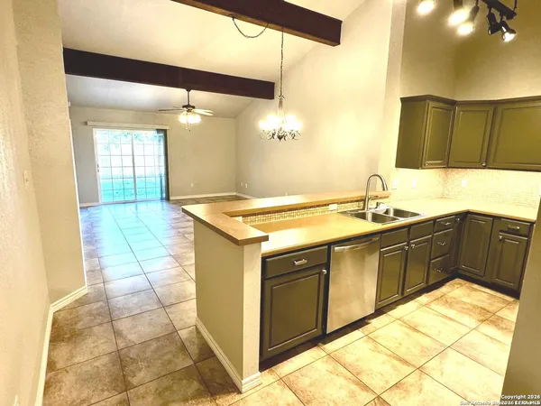 a kitchen with a sink a stove top oven and cabinetry