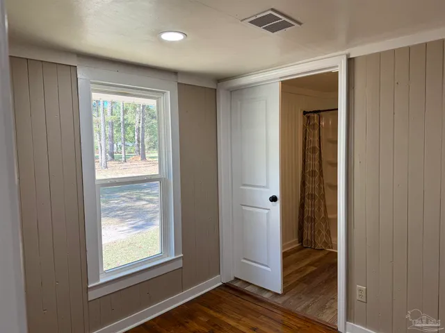 an empty room with wooden floor and a window