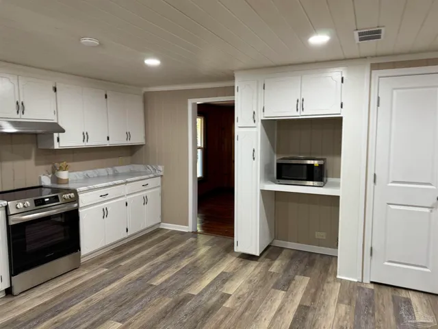 a kitchen with a stove a sink and a window