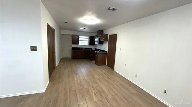a view of a big room with wooden floor and a window