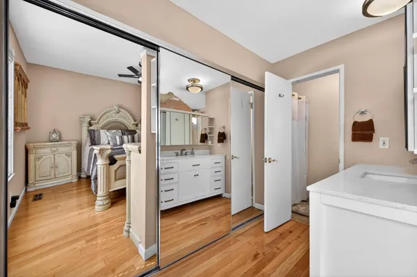 a living room with furniture large window and wooden floor