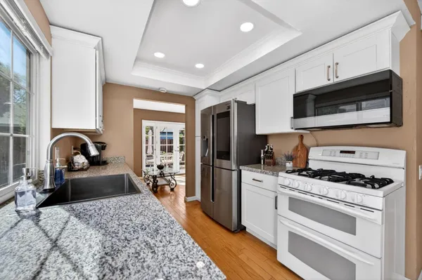 a view of a patio with table and chairs potted plants and floor to ceiling window
