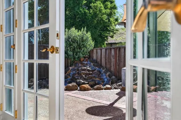 a view of a patio with a table and chairs under an umbrella with wooden fence